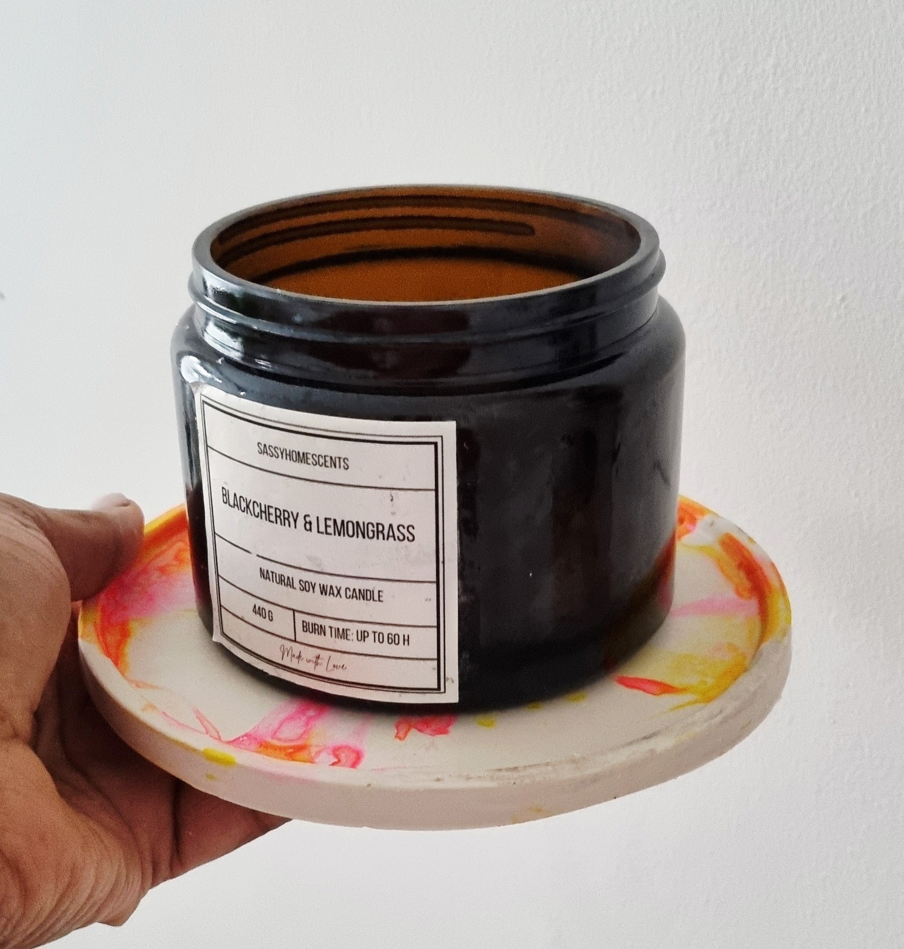 Amber glass candle on a handmade colorful coaster, perfect for home decor