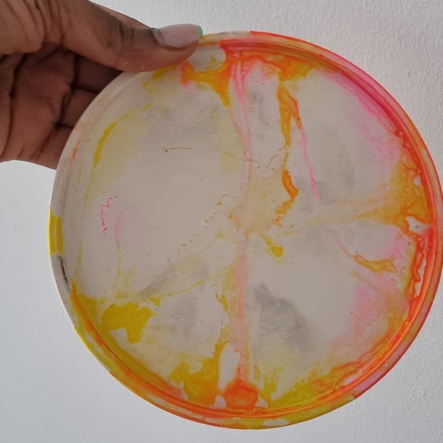 Close up of handmade plaster coasters for candles yellow and pink candle coaster