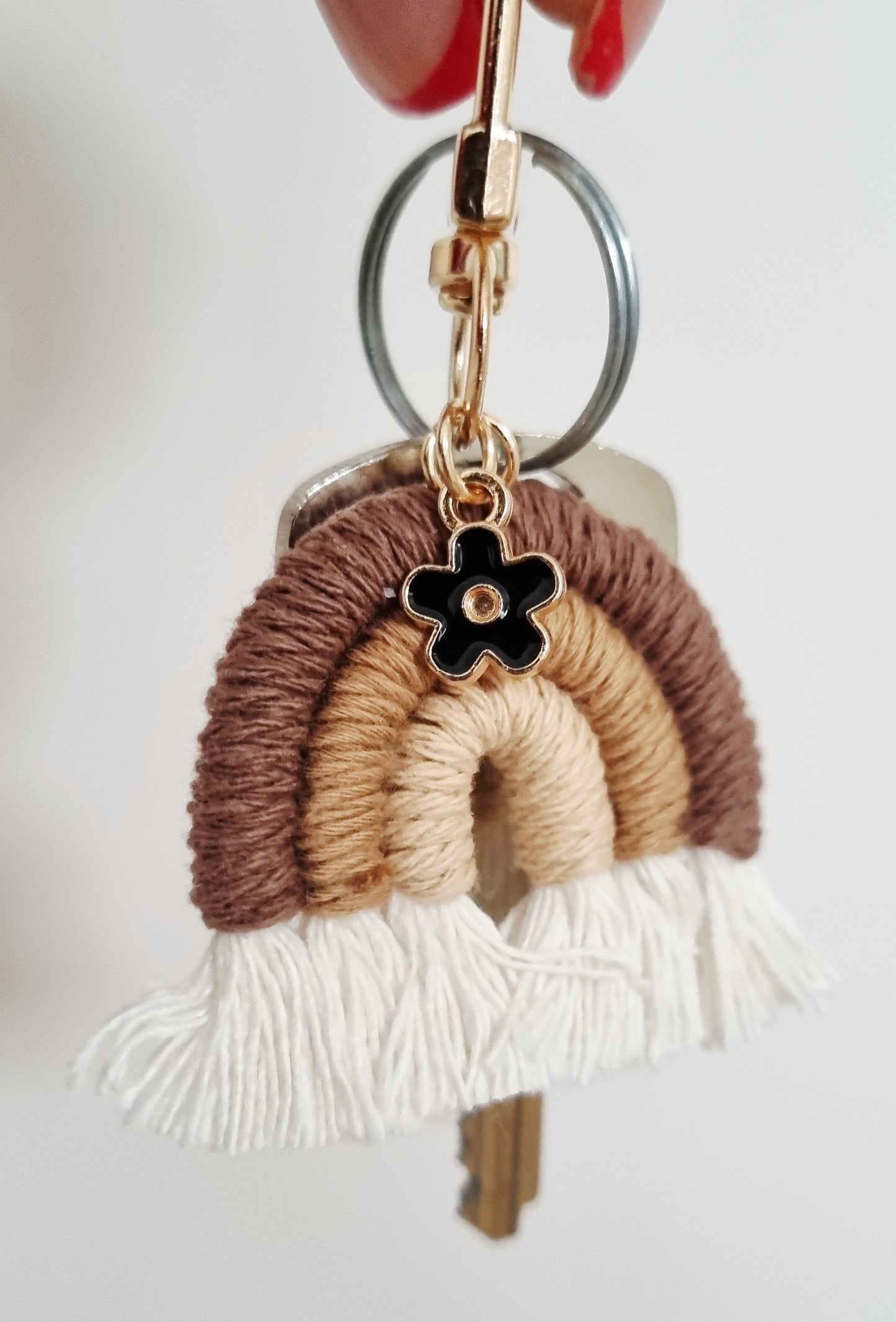 Keychain with woven design and flower charm on white background